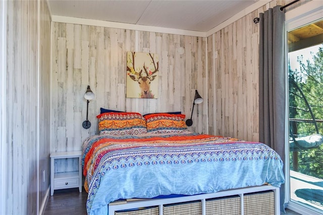 bedroom featuring wood finished floors and wood walls