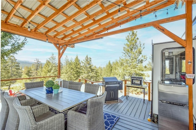 wooden terrace with outdoor dining space and area for grilling