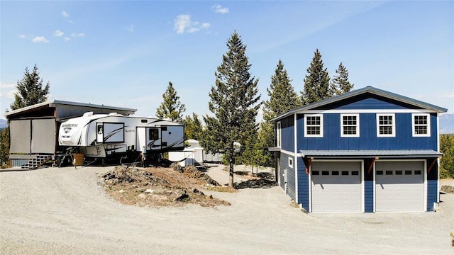 view of front of home with board and batten siding, a garage, and dirt driveway