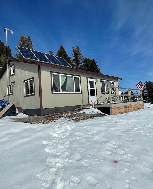manufactured / mobile home with roof mounted solar panels and a wooden deck