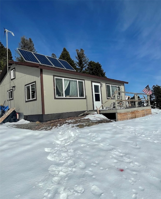 manufactured / mobile home with roof mounted solar panels and a deck