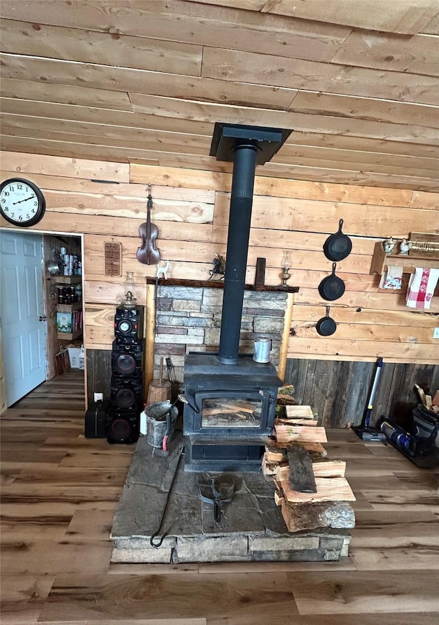 details featuring wood finished floors, a wood stove, and wood walls