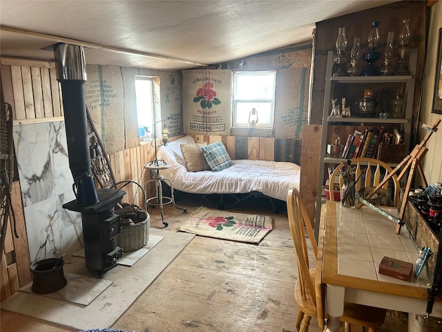 bedroom with lofted ceiling and a wood stove