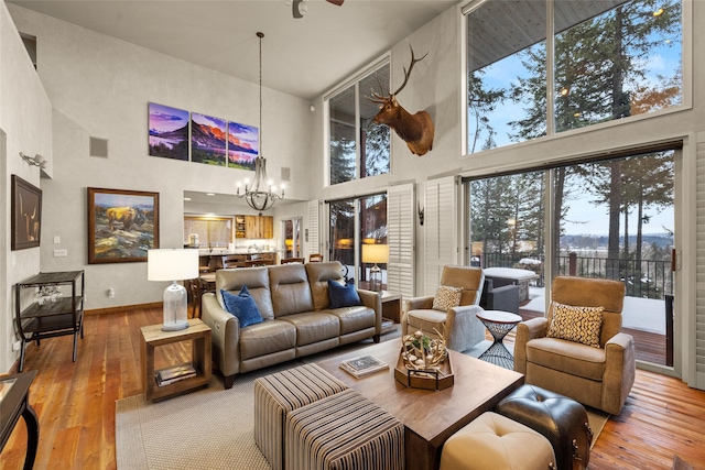 living area with hardwood / wood-style flooring, baseboards, visible vents, and a chandelier