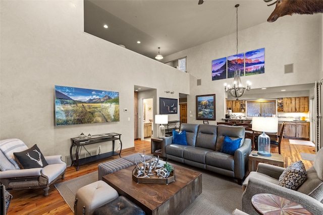 living room with recessed lighting, a notable chandelier, and wood finished floors