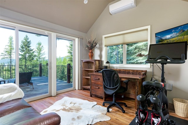 office featuring a healthy amount of sunlight, vaulted ceiling, wood finished floors, and a wall mounted air conditioner