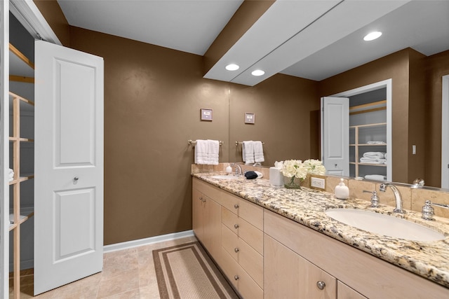 bathroom featuring double vanity, recessed lighting, a sink, and baseboards