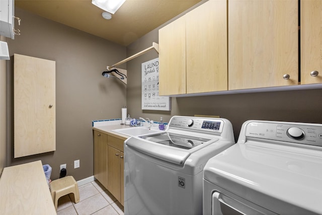 laundry room with light tile patterned floors, a sink, cabinet space, and washer and dryer