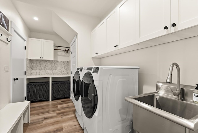 laundry room featuring recessed lighting, cabinet space, light wood-style flooring, a sink, and independent washer and dryer