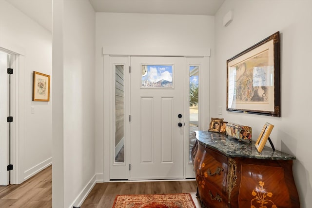 foyer featuring baseboards and wood finished floors