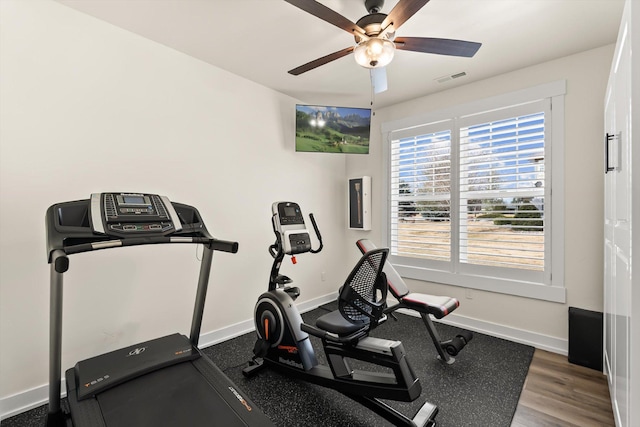 workout room featuring a ceiling fan, wood finished floors, visible vents, and baseboards