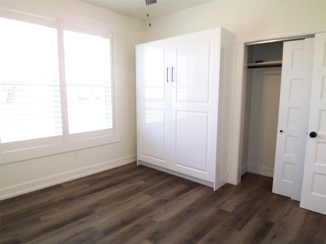 1228 Quail Ridge Dr, Kalispell, MT 59901 - unfurnished bedroom featuring dark wood-type flooring, multiple windows, and a closet