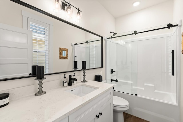 bathroom with combined bath / shower with glass door, vanity, and toilet