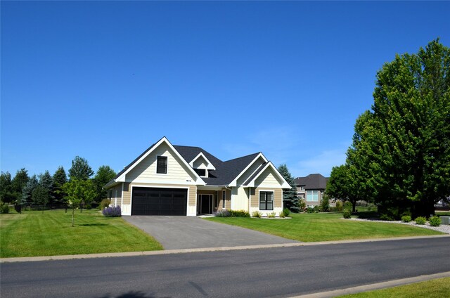 1228 Quail Ridge Dr, Kalispell, MT 59901 - view of front of home featuring a front yard, a garage, driveway, and board and batten siding