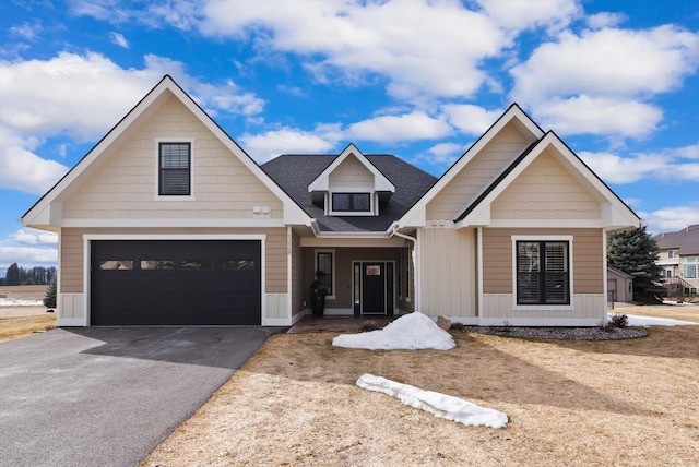 view of front of house with a shingled roof and aphalt driveway