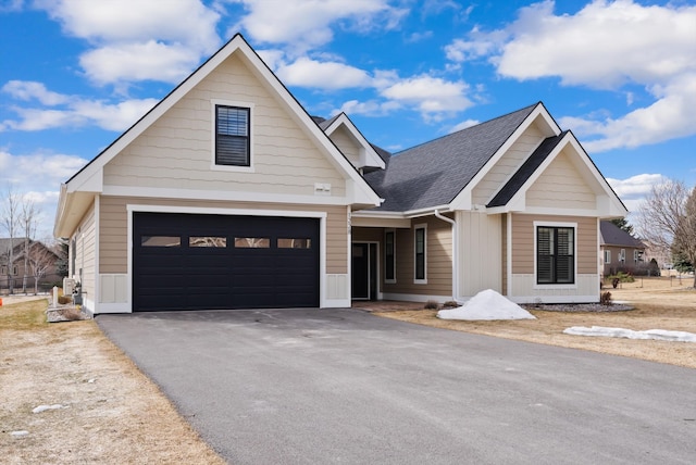 view of front facade featuring aphalt driveway and roof with shingles