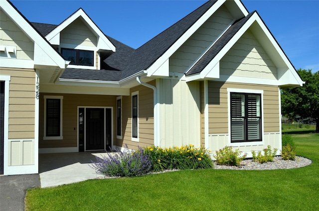 1228 Quail Ridge Dr, Kalispell, MT 59901 - view of front facade featuring a front lawn, roof with shingles, and board and batten siding