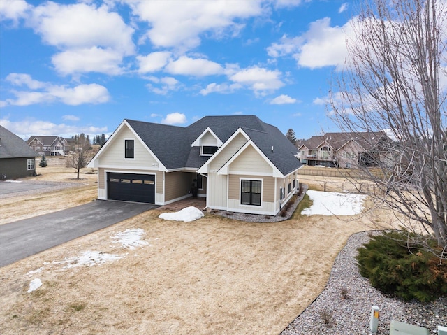 view of front of house featuring a garage, driveway, and roof with shingles