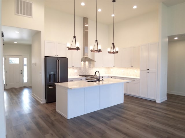 1228 Quail Ridge Dr, Kalispell, MT 59901 - kitchen with black fridge with ice dispenser, a high ceiling, dark wood-style floors, white cabinets, and recessed lighting
