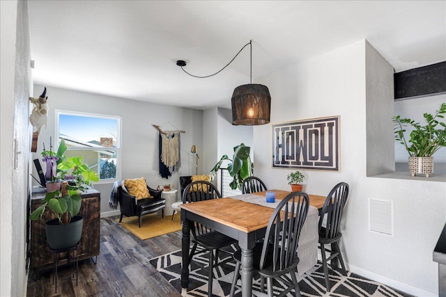 dining area featuring dark wood-type flooring and baseboards