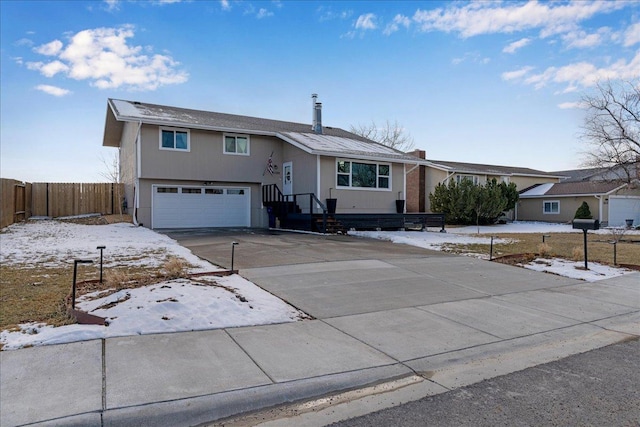 view of front of home with a garage, driveway, and fence