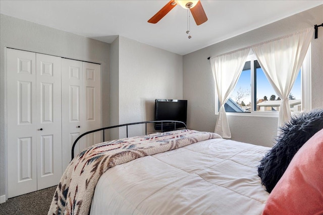 carpeted bedroom featuring ceiling fan, a textured wall, and a closet