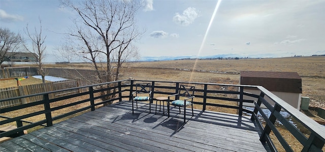 wooden deck featuring a rural view and fence