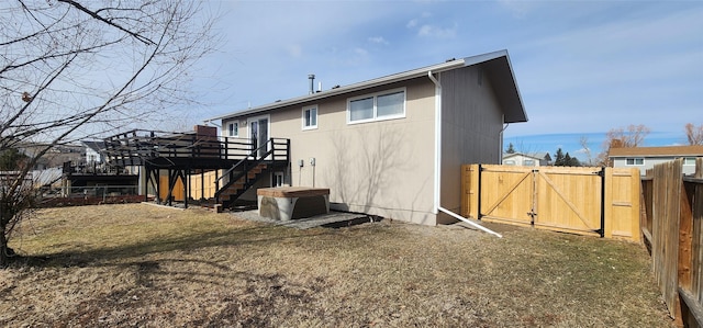 back of house with a gate, stairway, fence, and a wooden deck