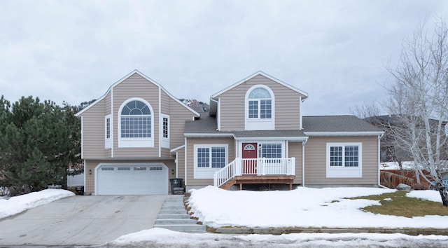 view of front of house featuring driveway, a shingled roof, and a garage