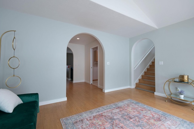 interior space with stairs, wood finished floors, and baseboards