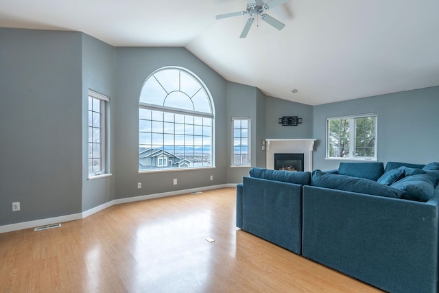 1949 University St, Helena, MT 59601 - living area featuring vaulted ceiling, wood finished floors, a ceiling fan, and a glass covered fireplace