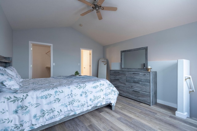 bedroom with vaulted ceiling, light wood finished floors, and a ceiling fan