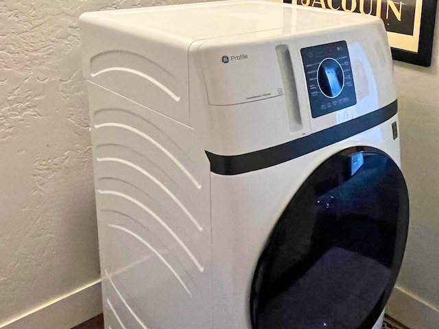 interior details with washer / clothes dryer and a textured wall