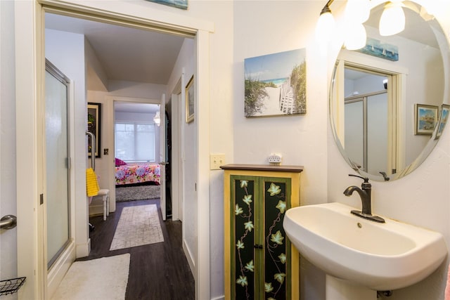 ensuite bathroom featuring a stall shower, a sink, ensuite bathroom, and wood finished floors