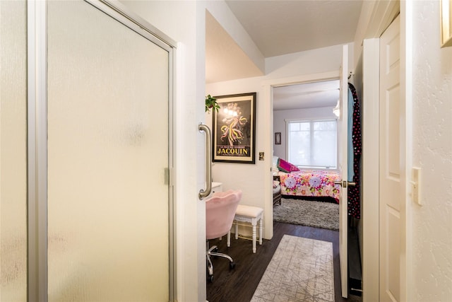 ensuite bathroom featuring a stall shower, ensuite bath, and wood finished floors