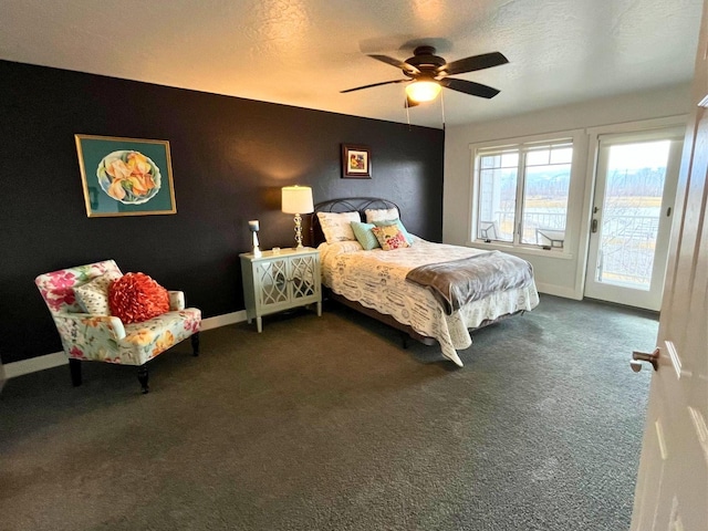 bedroom with baseboards, a ceiling fan, access to exterior, a textured ceiling, and dark carpet