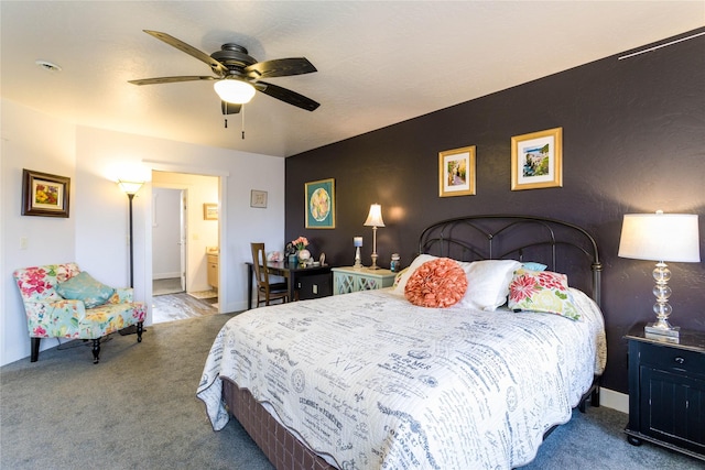 carpeted bedroom with ensuite bath, ceiling fan, and baseboards