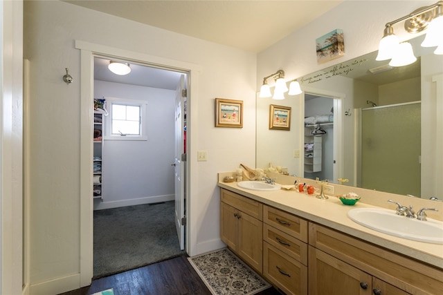 bathroom with a sink, a walk in closet, and a shower stall