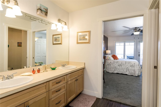 ensuite bathroom featuring a sink, double vanity, toilet, and connected bathroom