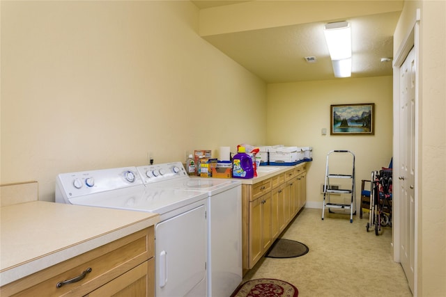 washroom featuring visible vents, separate washer and dryer, cabinet space, and light colored carpet