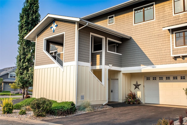 view of front of property with a garage, aphalt driveway, and board and batten siding