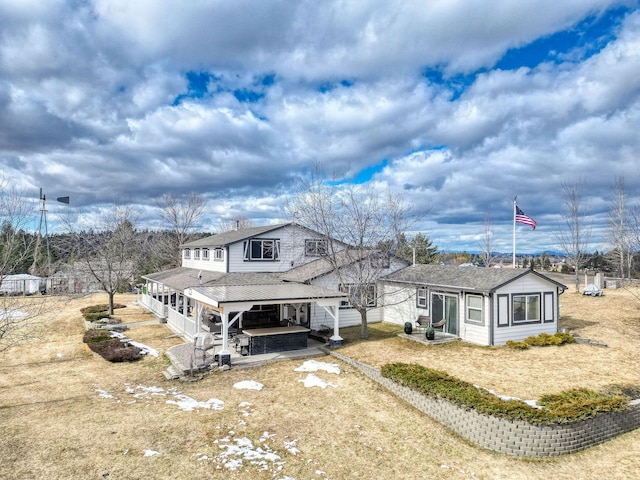 view of front of home featuring a patio and roof with shingles