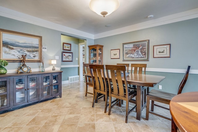 dining space with visible vents, baseboards, and crown molding