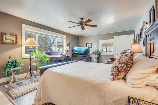 bedroom with wood finished floors, baseboards, and ceiling fan