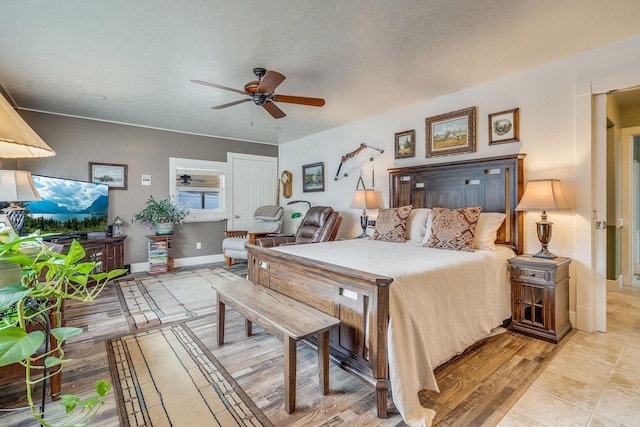 bedroom featuring light wood-type flooring, baseboards, and ceiling fan