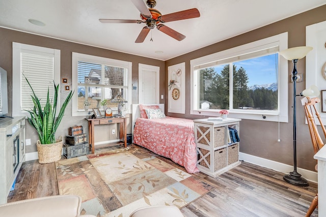 bedroom with ceiling fan, baseboards, and wood finished floors