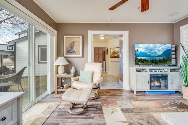 interior space featuring a glass covered fireplace and a ceiling fan