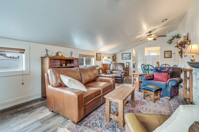 living area featuring vaulted ceiling, wood finished floors, baseboards, and ceiling fan