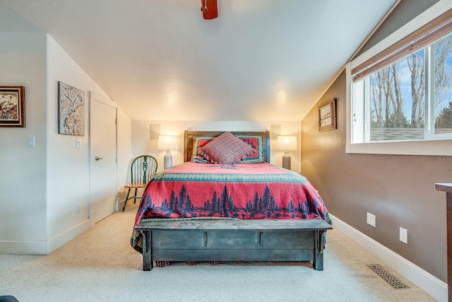 carpeted bedroom with visible vents, lofted ceiling, baseboards, and a ceiling fan