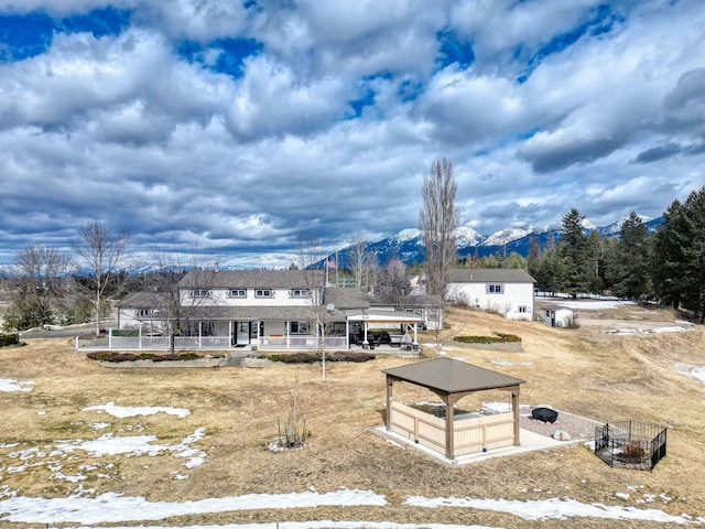 rear view of property with a gazebo and a mountain view